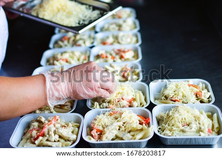takeaway chicken salad with vegetables and cheese food delivery. preparing portions in containers. service food order online delivery in quarantine covid-19. airline food. airline meals and snacks 商業照片 © 