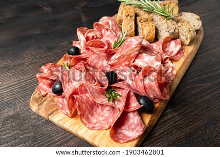 Italian antipasti salami with bread.  with olives and multigrain baguette.  italian food, appetizer for aperitif or salami sandwich. Top view Elegant serving of snacks in the restaurant