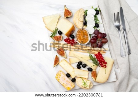 elegant serving cheese board with pecorino cheese brie goat cheese with crackers and grissini breadsticks, Italian and French cheese with figs jam olives and berries Foto stock © 