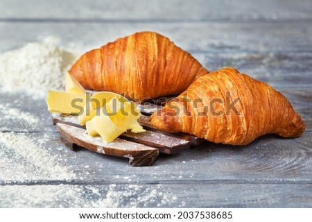 French cuisine. Croissants with butter. Bakery. Organic products. Bakery products. French croissant on a wooden background.