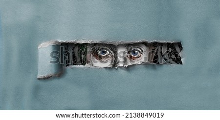 A female with blue eyes peers through a hole torn in cardboard in this 3-d illustration. Stock fotó © 