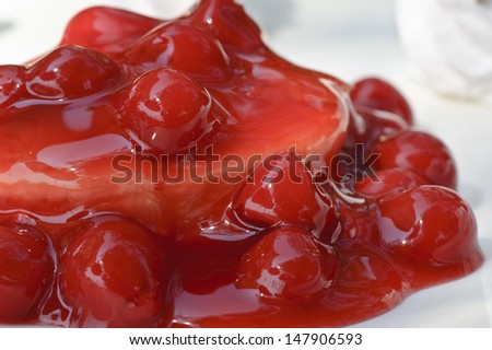 Cherry on a cake served with cherry sauce.  Enjoy for dessert any day of the week.