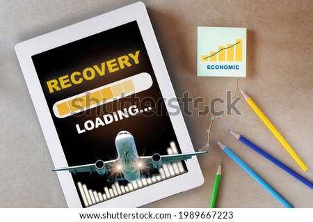Airplane business recovery after covid-19 impact to airplane transport industry crisis concept and business travel idea. Recovery loading on computer digital tablet with airplane and growth graph 