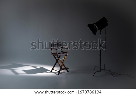 Empty photo studio with lighting equipment. Space for text. Vacant directors chair. The concept of selection and casting. Job recruitment advertisement.