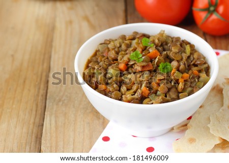 Vegan dinner - green lentils with vegetables on wooden rustic table
