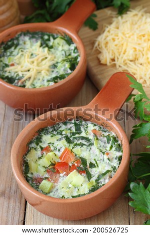 Omelette with vegetables and herbs cooked by steaming in ceramic pots