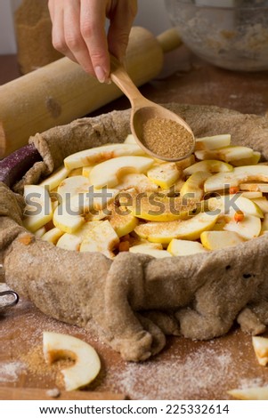 Apple pie with common sea-buckthorn and cinnamon on wooden background