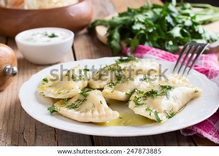 Traditional dish of Slavic cuisine. Varenyky on a white plate on wooden table