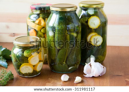 Preserved cucumbers and other vegetables in glass jars. Traditional Russian appetizer