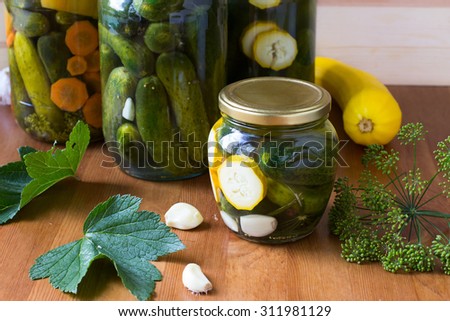 Preserved cucumbers and other vegetables in glass jars. Traditional Russian appetizer