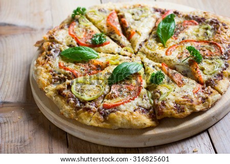 Homemade veggie pizza with cheese, basil, tomatoes and bell pepper