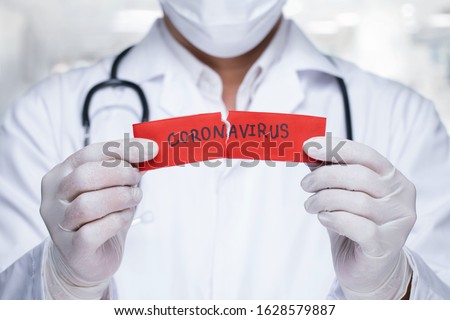 Concept of coronavirus quarantine. MERS-Cov.Novel coronavirus (2019-nCoV).Doctor with a stethoscope Tear the red paper with the word coronavirus.      