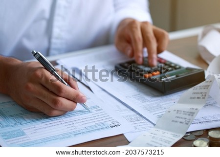 Man hand filling US tax form. tax form us business income office Financial document. Tax time.Tax concept. Close-up.