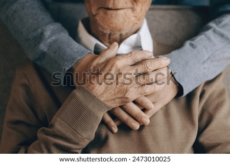 Similar – Image, Stock Photo Hands of a young person hold purple colored smartphone. The arms are placed on a wooden table top.