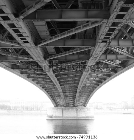 black and white photo of an abstract steel construction from under the bridge