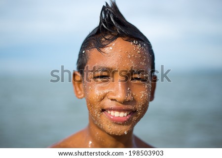 SURATTHANI, THAILAND - JUNE 6 : Unidentified boy, face covered with sand on June 6, 2014 in Lamsui Beach, Chaiya, Suratthani, Thailand. Lamsui Beach is one of famous beach in Chaiya, Suratthani.