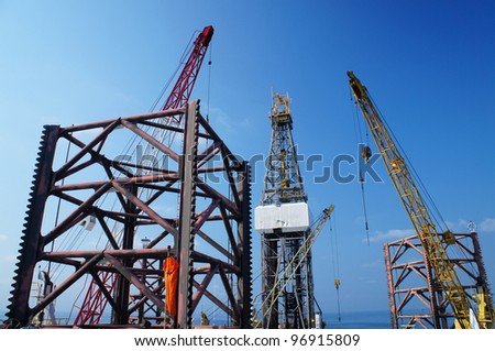 Jack Up Offshore Drilling Rig With Rig Cranes on Sunny Day in The Middle of Ocean