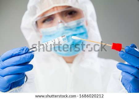 Medical healthcare NHS technician holding COVID-19 swab collection kit,wearing white PPE protective suit mask gloves,test tube for taking OP NP patient specimen sample,PCR DNA testing protocol process Foto stock © 