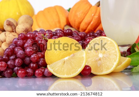 Lemon Fruit and slice piece in Dump of Fruit, Grape, Longkong, Longan, Pomegranate, Banana, Pumpkin, Squash Lemon and Lime juice in a shape glass