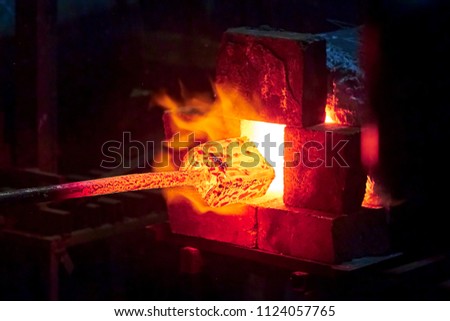 Burning  in a blacksmith forge.  Making metal items in smithy. In the smithy a red-hot iron piece in a hot fire flame is ready for further processing Stock fotó © 