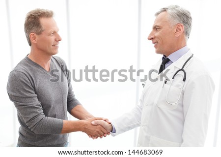 Thankful patient. Thankful mature patient shaking doctors hand
