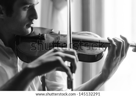 Practicing in playing the violin. Black and white portrait of men playing the violin