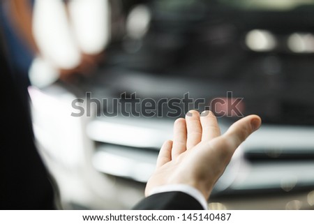 Here is your new car. Close-up shoot of the hand presenting a car