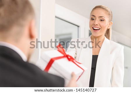 The man gives a gift to a young  woman
