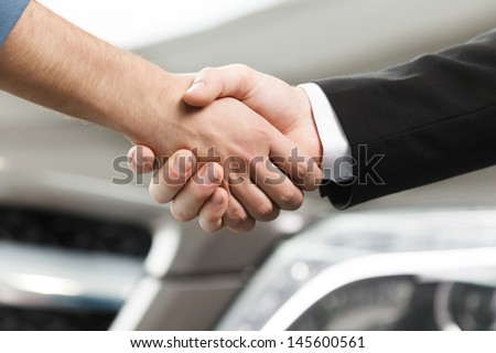 Good deal. Close-up shoot of the hands shaking in front of the car