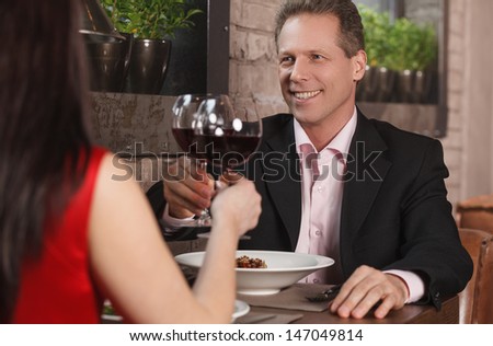 Spending their time together at the restaurant. Mature couple drinking wine at the restaurant
