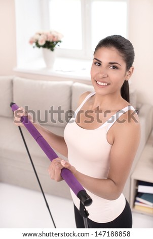 Sport at home. Top view of beautiful young women in sports clothing exercising at home and looking at camera