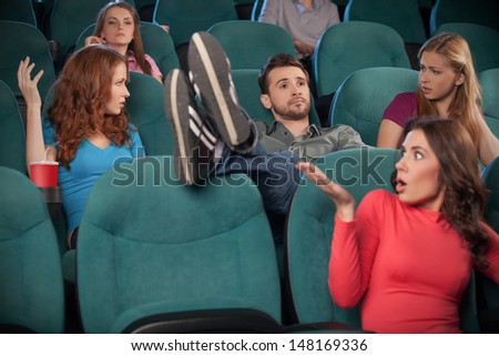 I donÃ?Â¯Ã?Â¿Ã?Â½ care about anyone. Young men holding his feet on the seat while watching movie at the cinema