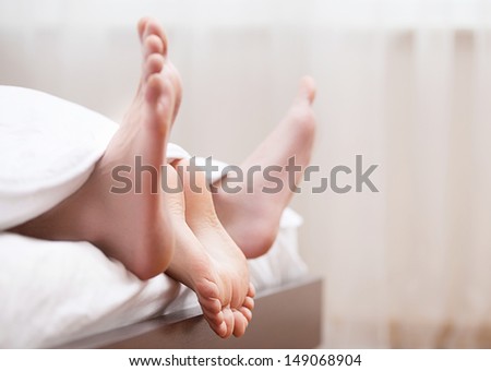 Couples feet in bed. Close-up of couples feet in bed