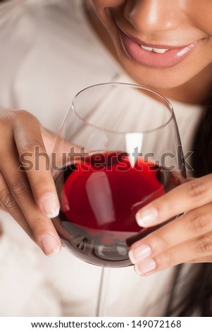 Women drinking wine. Cropped image of beautiful African descent woman drinking wine