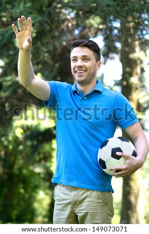 Man with soccer ball. Cheerful young man holding a soccer ball and gesturing
