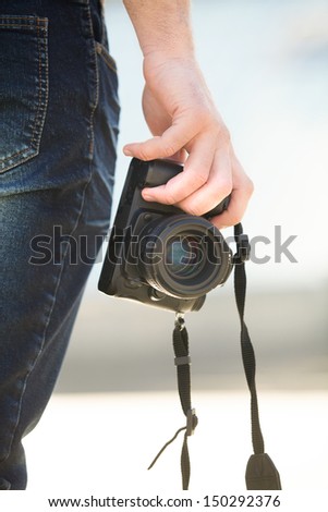 Digital camera. Close-up of man holding digital camera in his hand