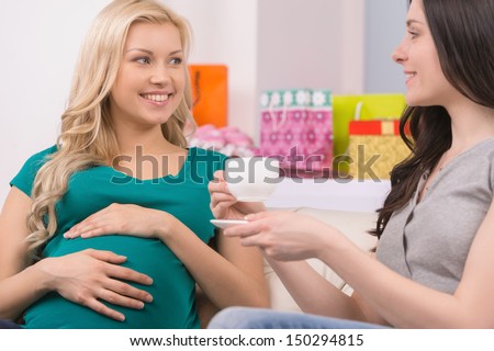Pregnant woman on Baby Shower party. Beautiful young women talking to her friend and drinking tea