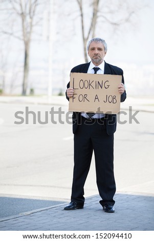 Looking for a job. Depressed senior man in formalwear holding poster Looking for a job