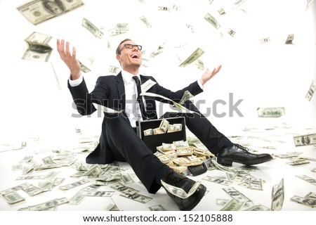 stock-photo-i-am-rich-happy-young-businessman-in-formalwear-throwing-money-up-while-sitting-near-the-case-full-152105888.jpg