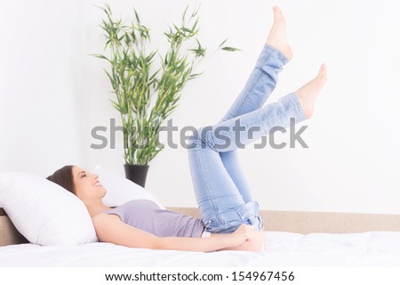 Woman dress up. Beautiful young woman lying on the sofa and dressing up