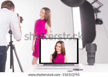 Photographer and model. Young man photographing model at studio