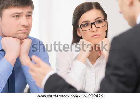 Two people listening to man. Woman with attention and man with bored face.