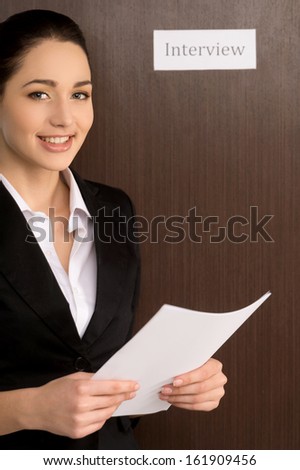 Smiling confident woman standing with CV. Getting ready for interview