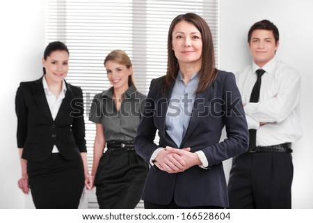 Grown up Successful business woman holding hands together. Young Smiling business people standing on blur background