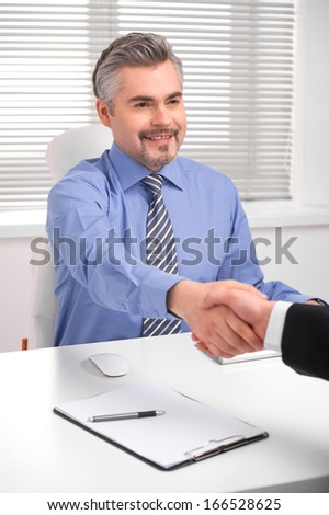 Smiling adult business man shaking hands. Close up of hand shake during successful negotiations
