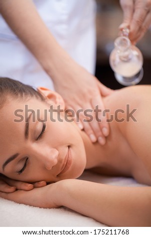 Beautiful woman having a wellness back massage. pretty woman laying on massage table and getting oil massage