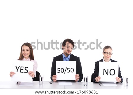three person sitting at table holding signs. two woman and man selling legally