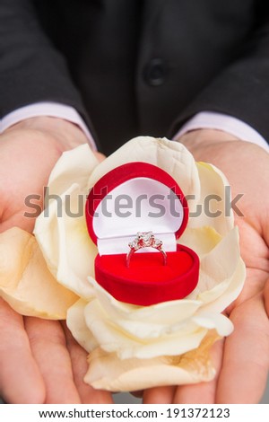 Marry me. Groom's hand offering wedding ring