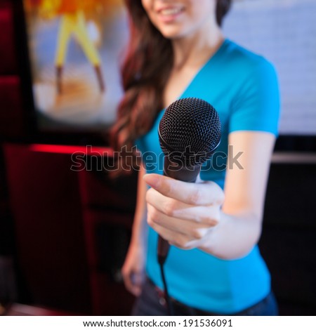 Karaoke microphone. Woman holding microphone during the karaoke
