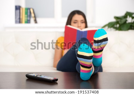 Funny socks. Woman reading a book in funny socks